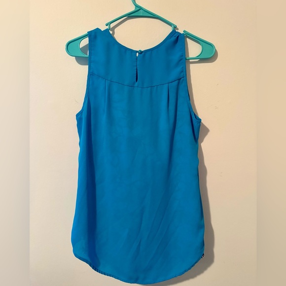 Teal blouse with teal and black highlights on a white skirt. - Picture 2 of 15